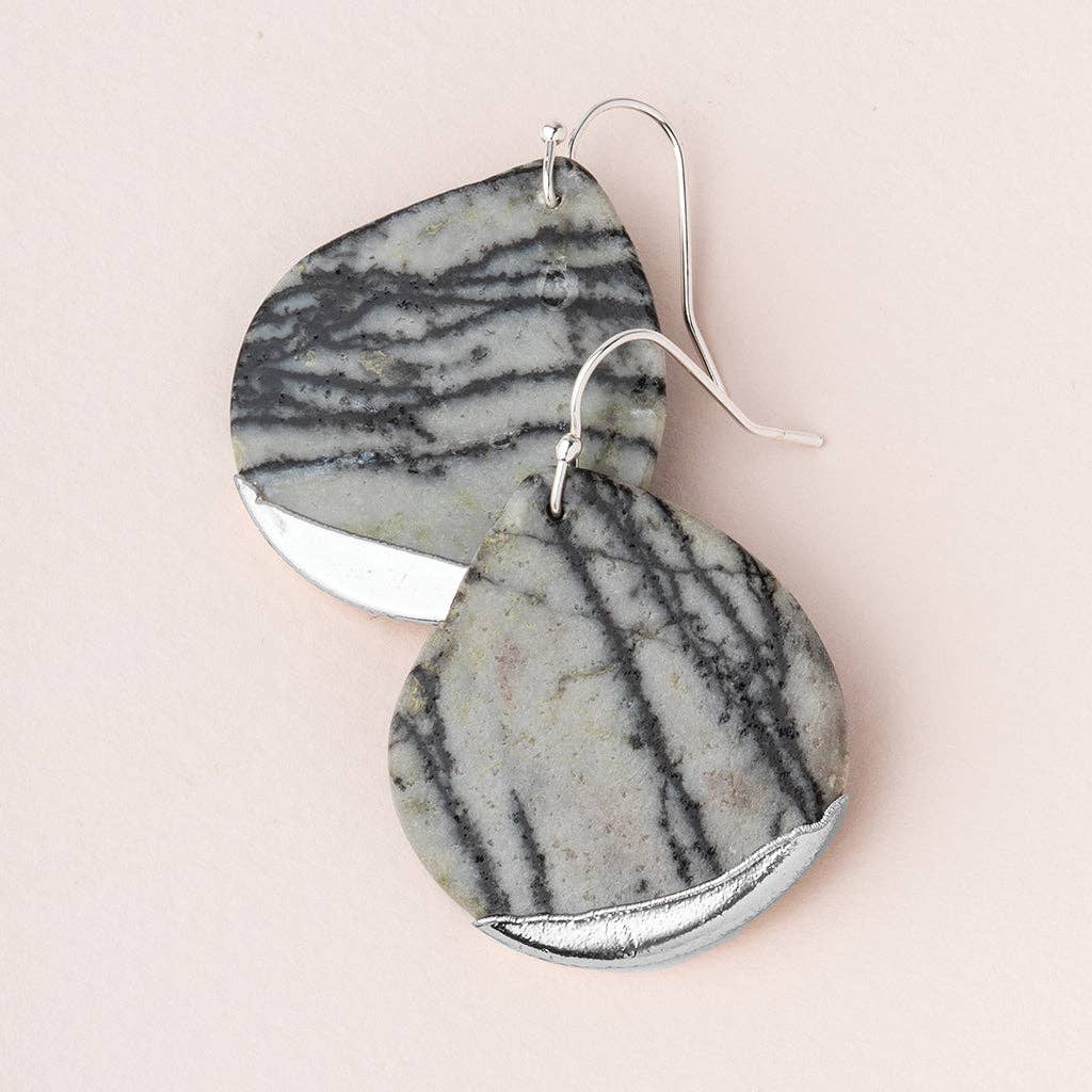 A pair of teardrop earrings with Picasso Jasper stone, dipped in silver, displayed against a pink background.