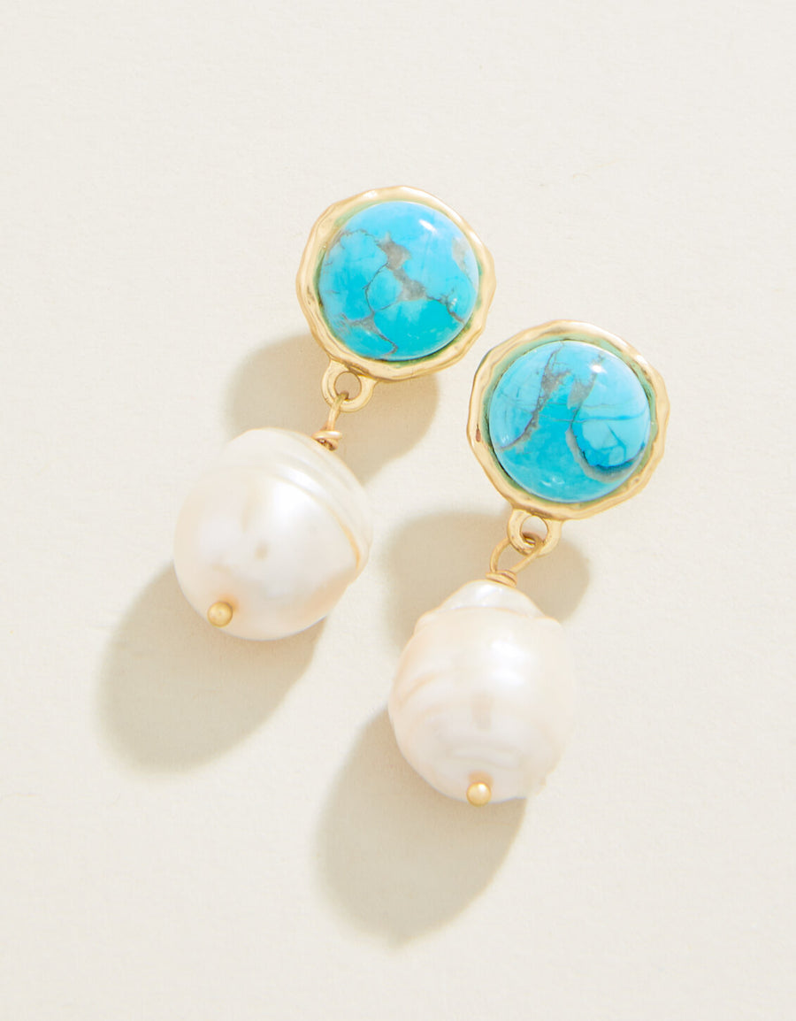 Earrings with turquoise stones and pearl-like drops on a light background