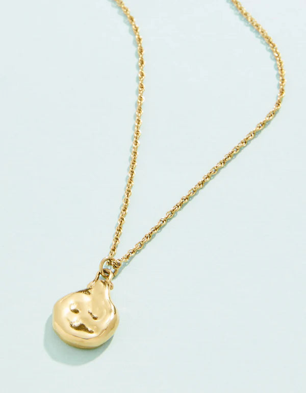 A gold-colored necklace with a small pendant, featuring a lobster clasp closure, on a light background.