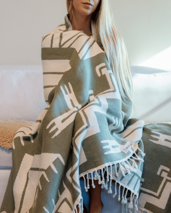 Person wrapped in a patterned blanket with geometric design