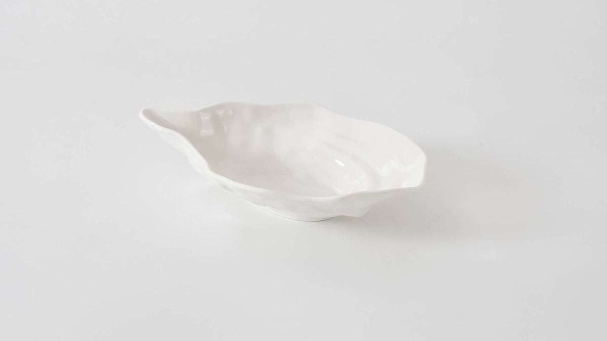 White ceramic leaf-shaped dish on a light gray background