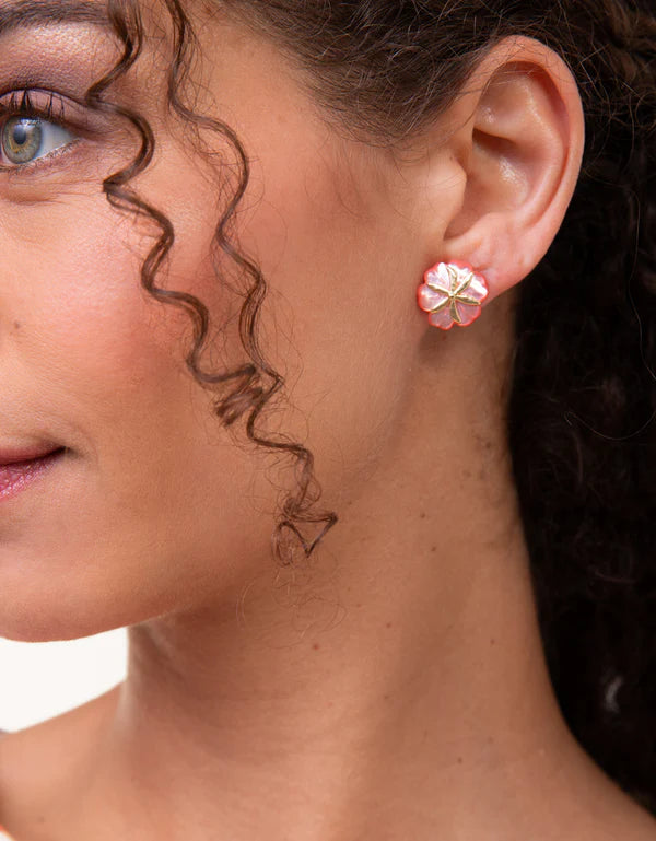 Close-up of a woman wearing pink flower-shaped earrings.