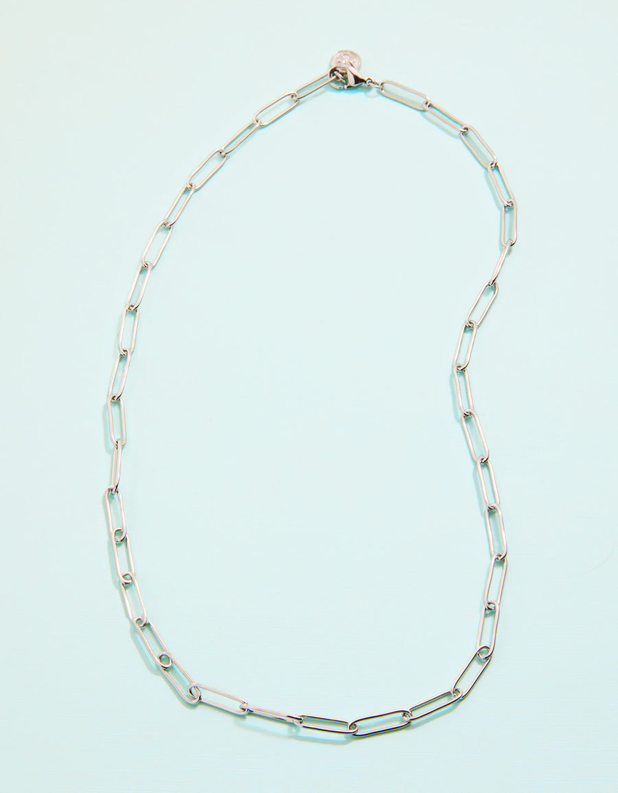 Silver chain necklace on a light blue background