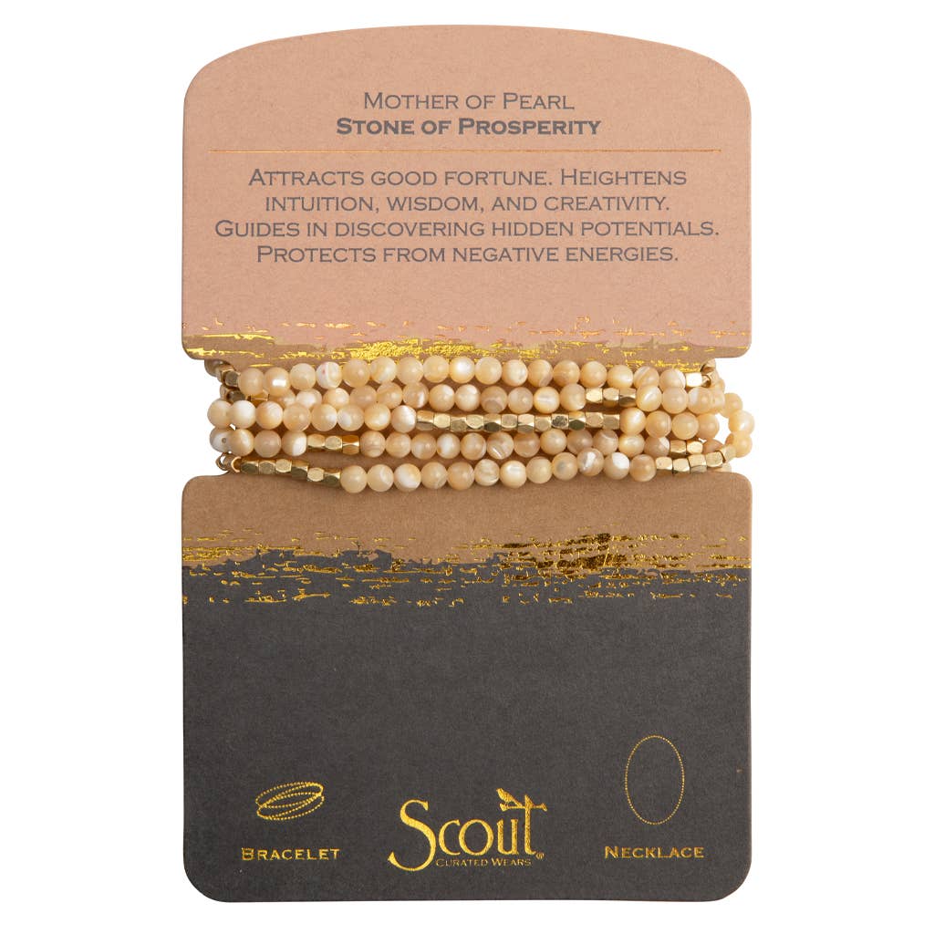 A bracelet made with mother of pearl and gold plated beads, presented on a card with the brand name 'Scout' and the product name 'Stone of Prosperity'.
