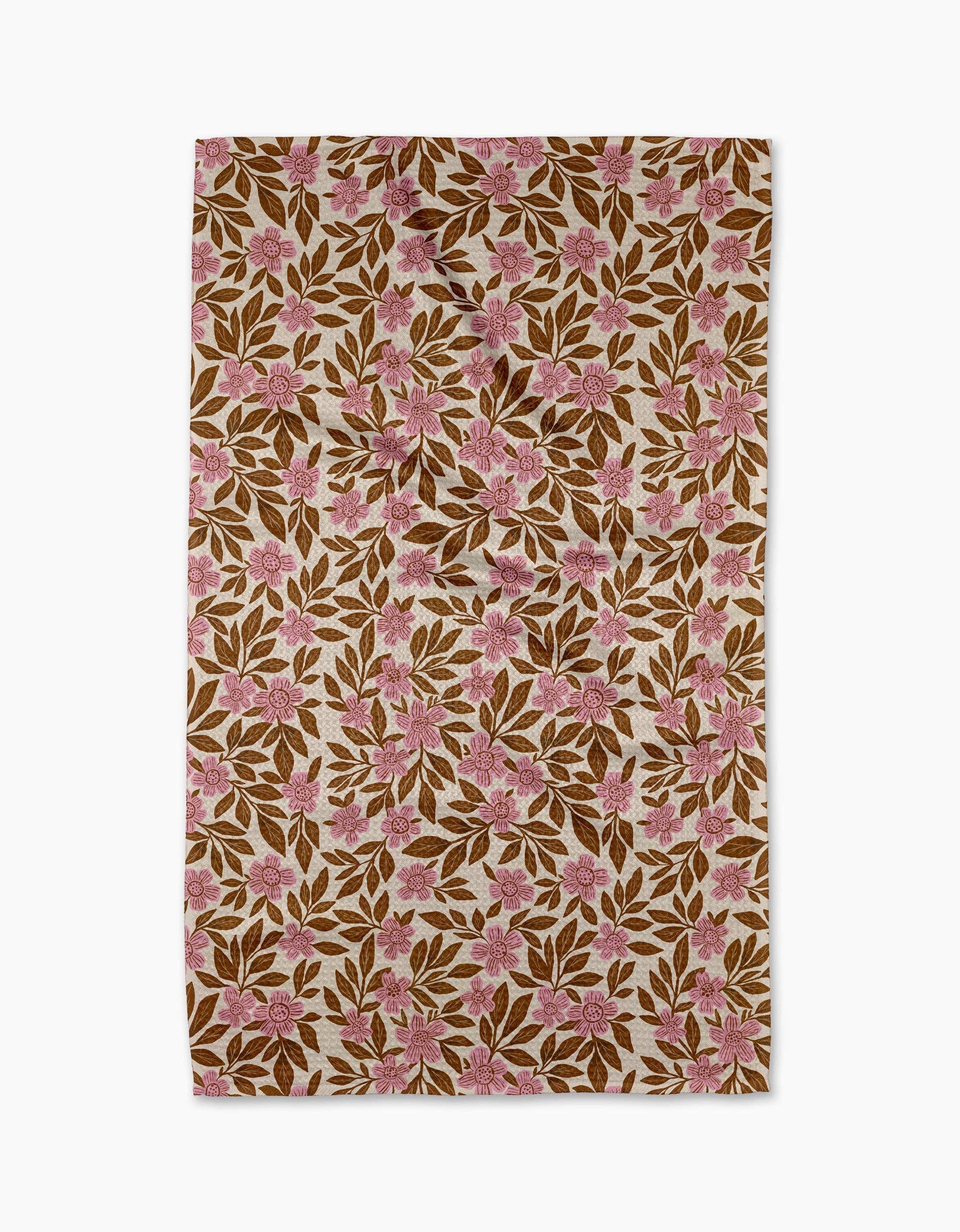 Floral patterned towel with pink flowers on a brown background