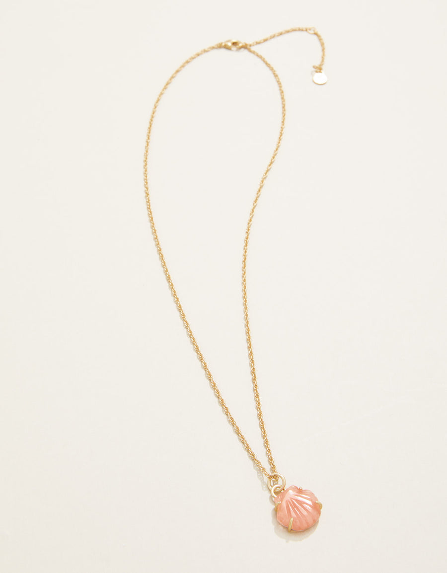 Gold necklace with a pink shell pendant on a white background