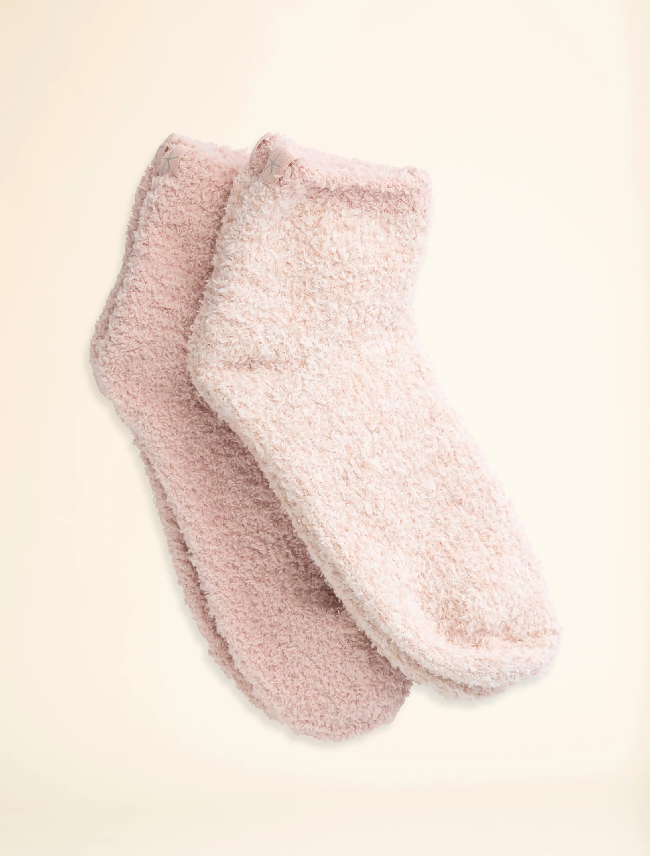A pair of pink tennis socks, one heathered and one solid color, displayed against a neutral background.