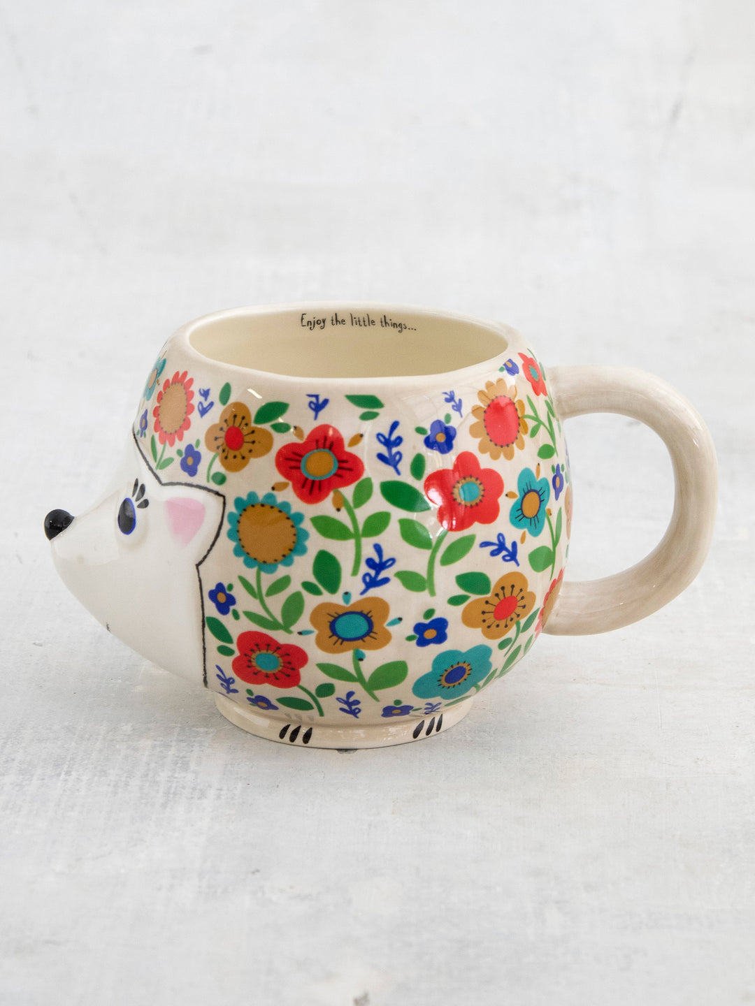 Hedgehog-shaped mug with floral design on a white background