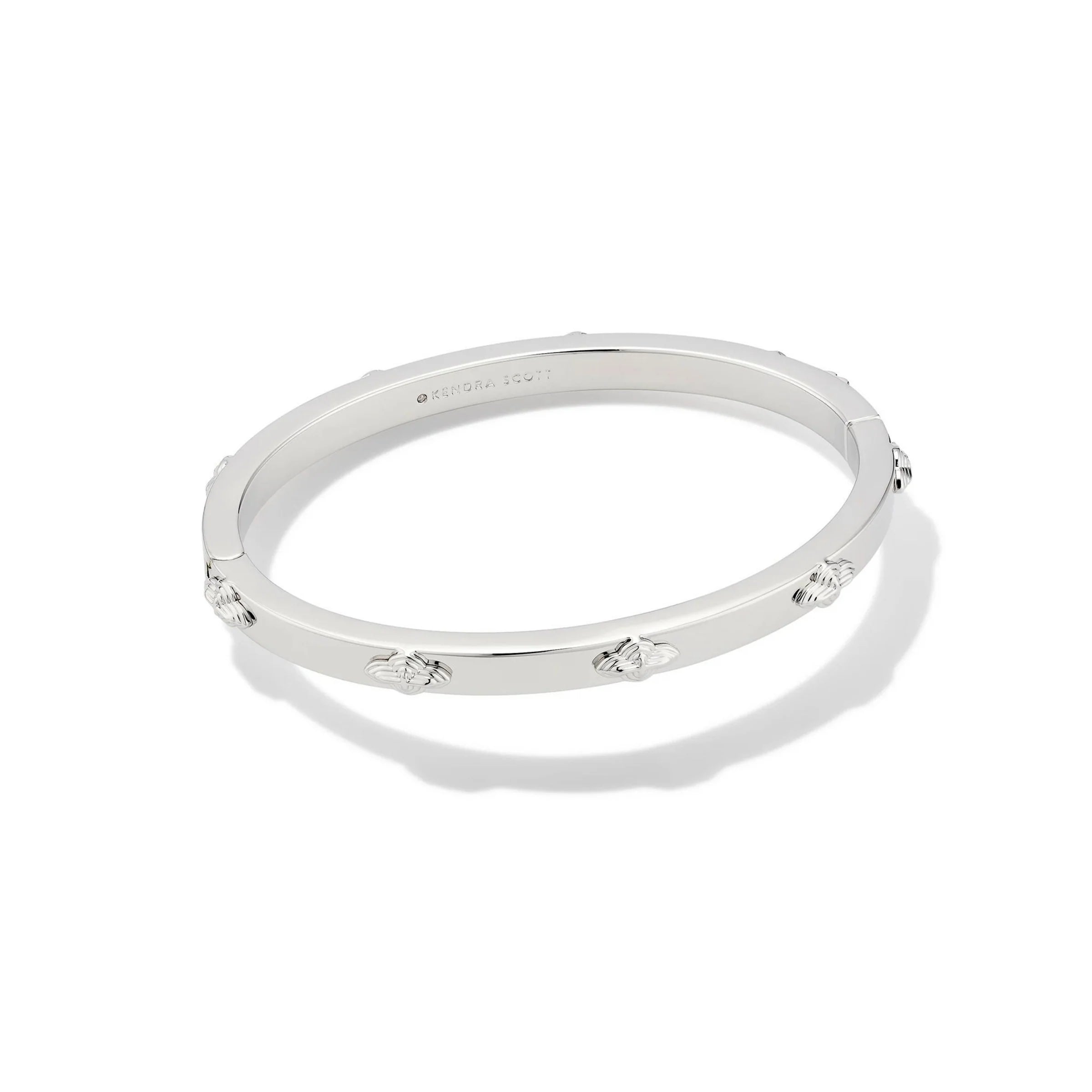 A silver metal bangle cuff bracelet with a lobster clasp closure, displaying a repeated motif design.