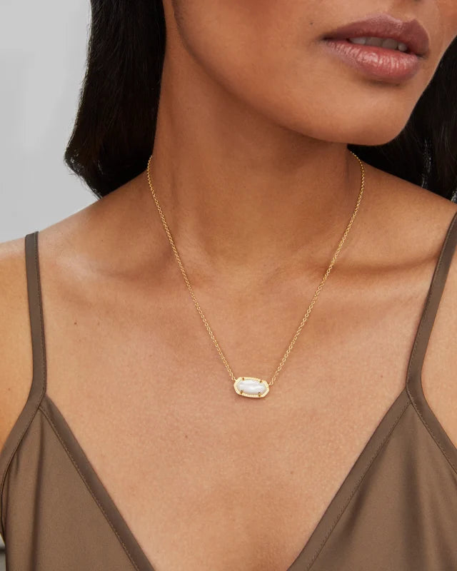 Gold necklace with a pendant worn by a person against a neutral background