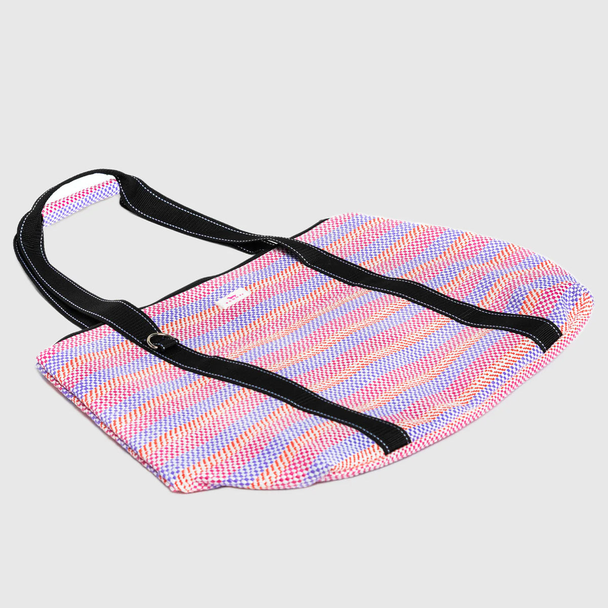 Multicolored striped bag with a black strap on a light gray background
