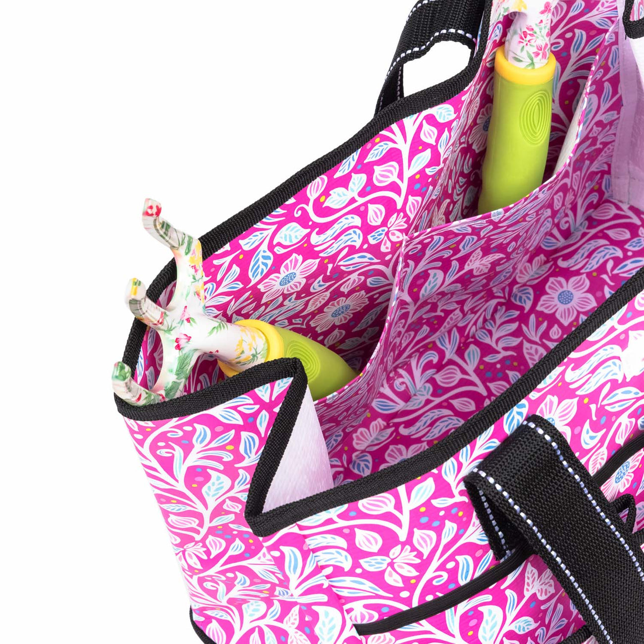 Pink floral-patterned bag with garden tools inside on a white background