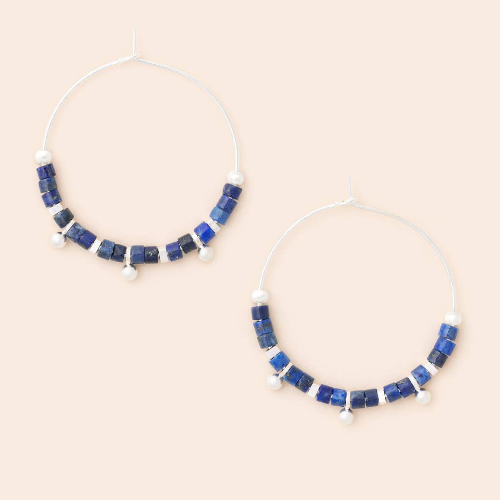 A pair of hoop earrings with lapis lazuli stone discs and silver accents, displayed against a neutral background.