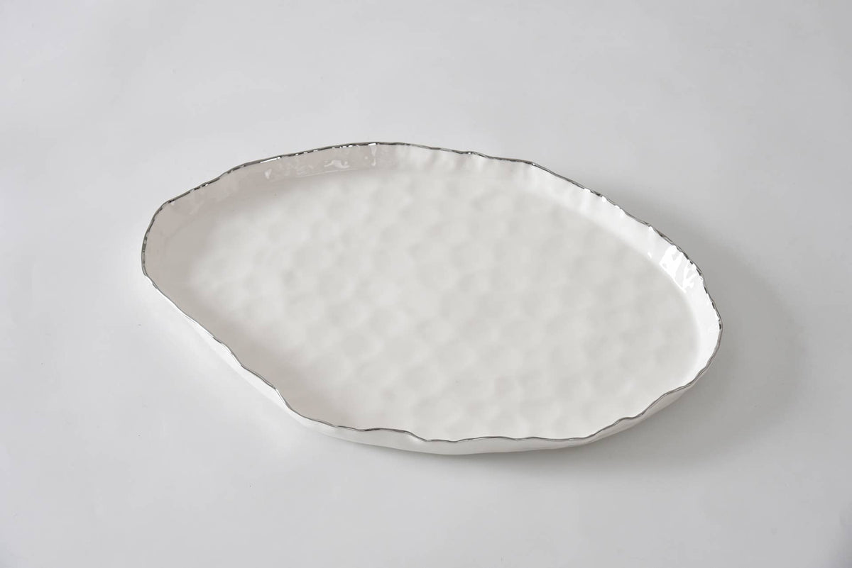 Decorative ceramic plate with textured edge on a light gray background