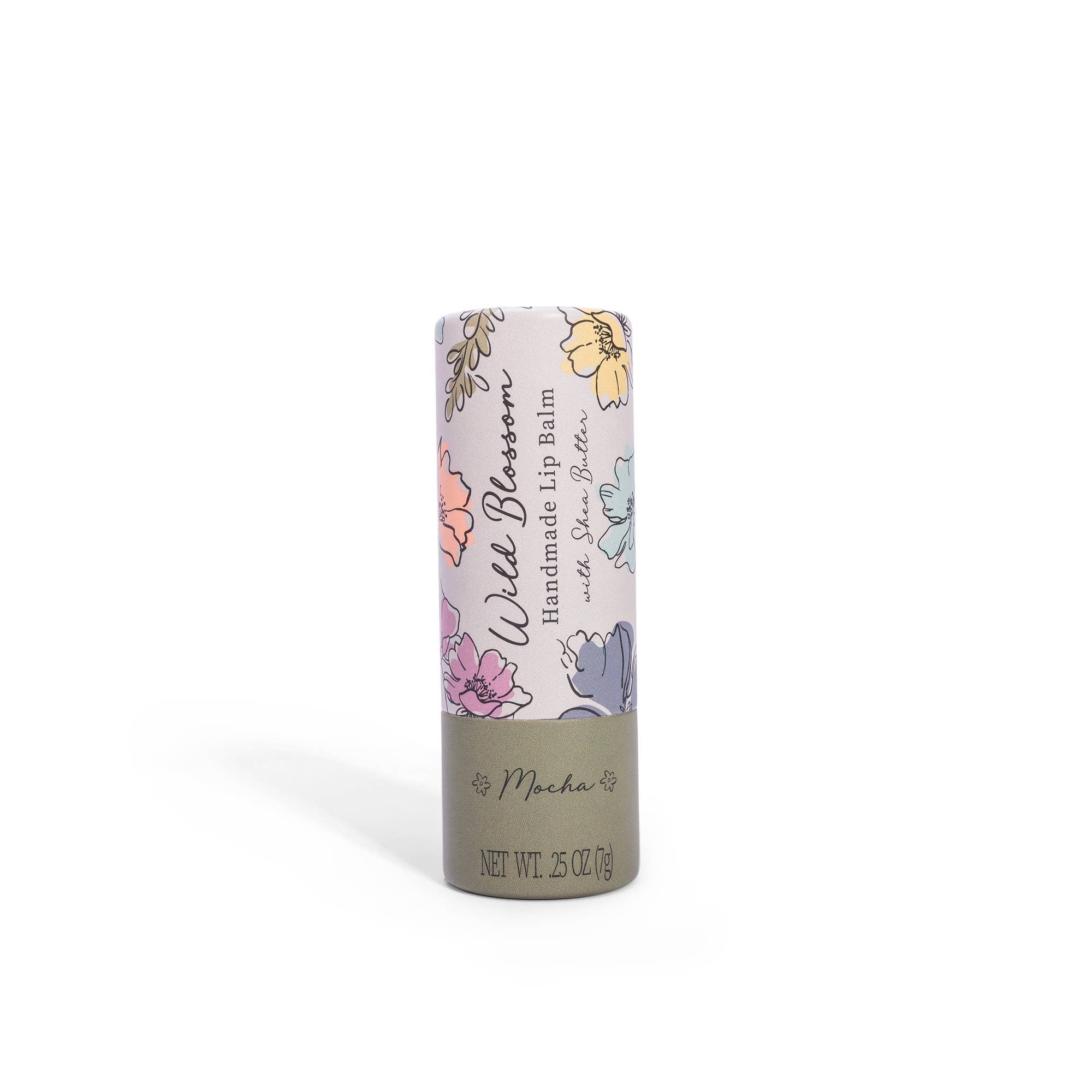 A tube of Wild Wildom Lip Balm by Cait + Co with floral patterns on the packaging, labeled 'Mocha' and indicating a net weight of 0.25 OZ (7g).