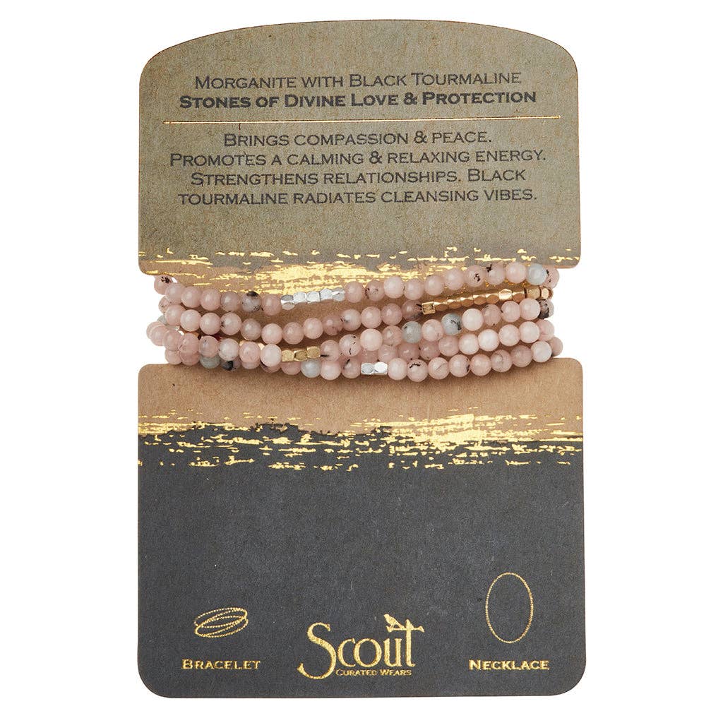 A bracelet made with pink and black tourmaline beads, featuring gold-plated brass accents, presented on a card with the brand name 'Scout' and the text 'Stones of Divine Love & Protection'.