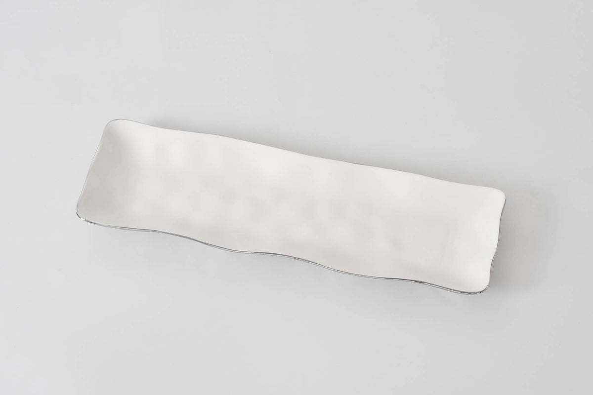 Silver lined white ceramic serving tray
on a light gray background
