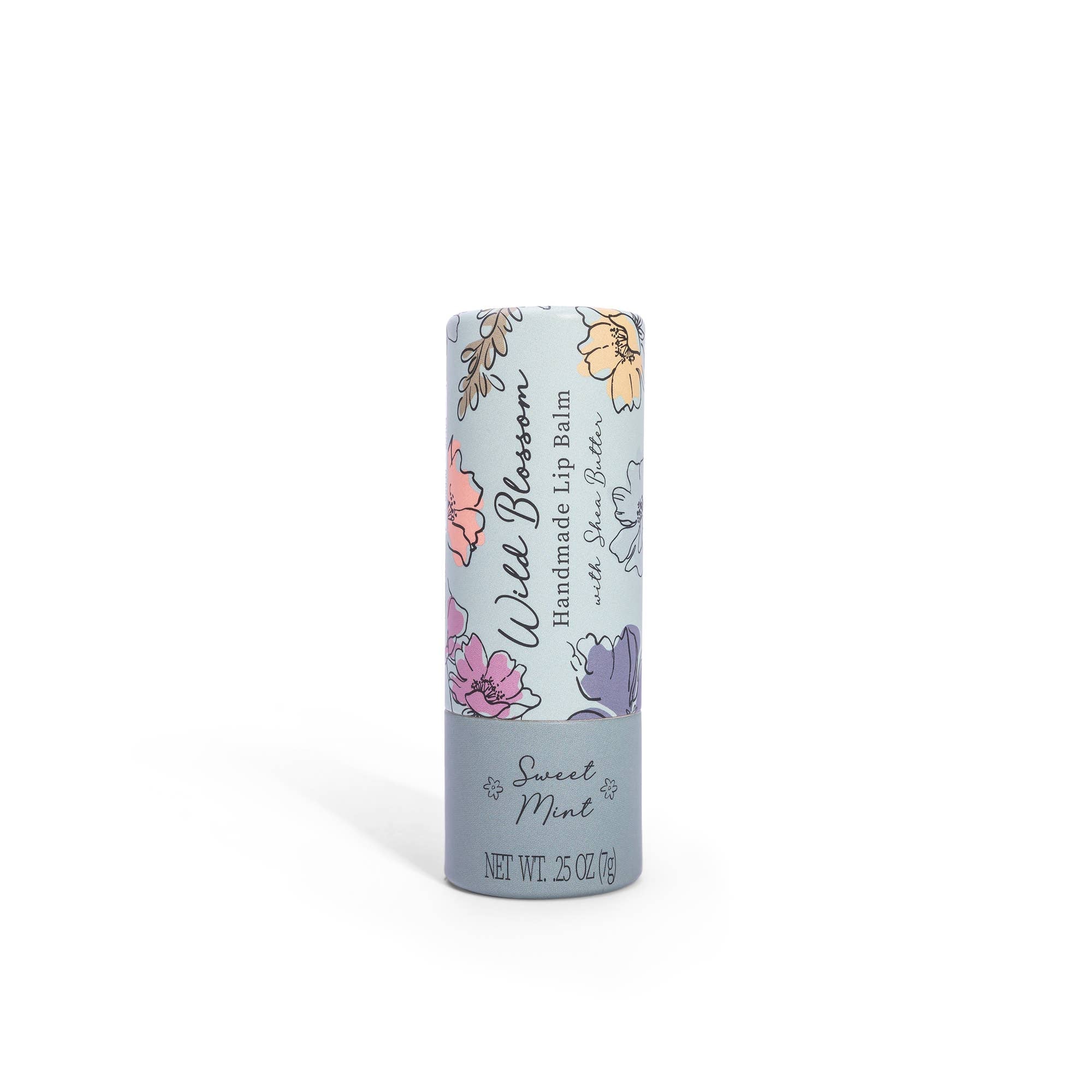 A tube of Wild Blossom Lip Balm with 'Sweet Mint' written on it, featuring floral designs and a mint background.