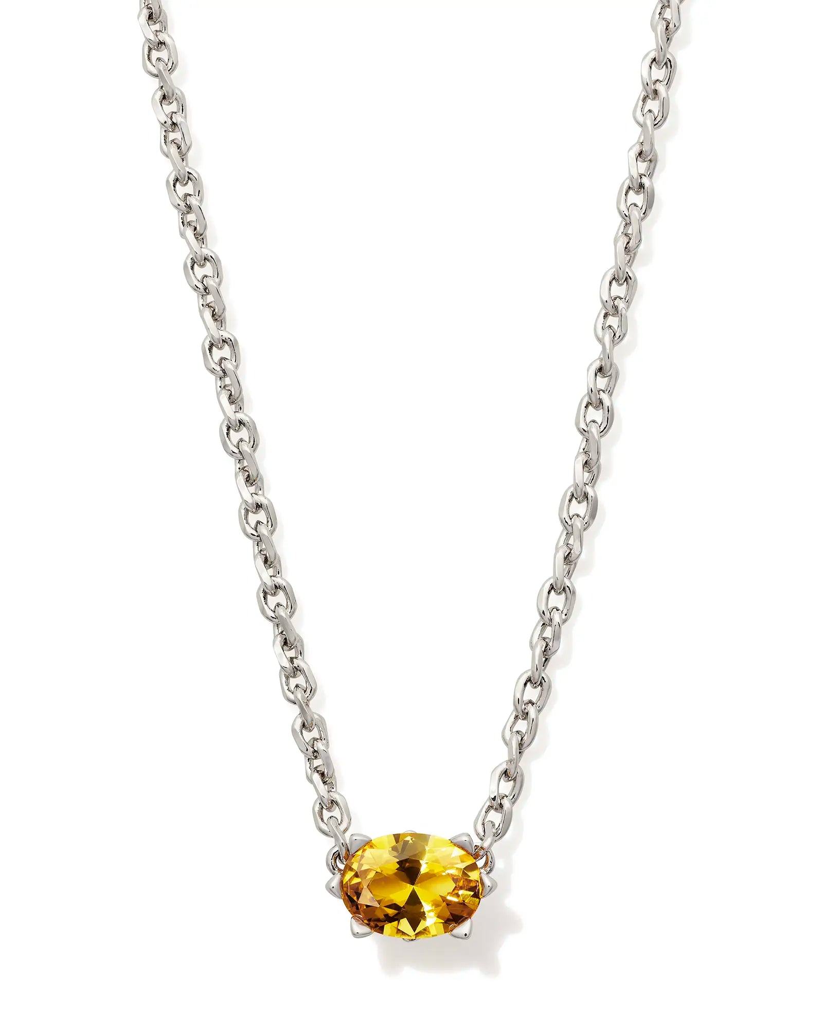 Silver necklace with a yellow gemstone on a white background