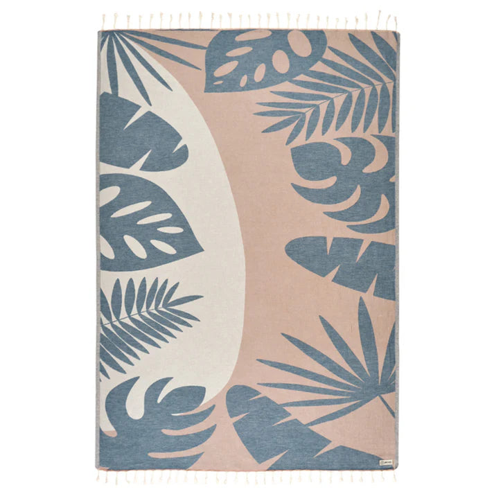 A large towel with a tropical leaves design in taupe color, made of Turkish organic cotton with a single jacquard weave and twisted tassels.