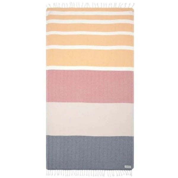 A striped beach towel with a combination of solid and striped patterns in shades of orange, pink, blue, and white, featuring fringe tassels on the edges.