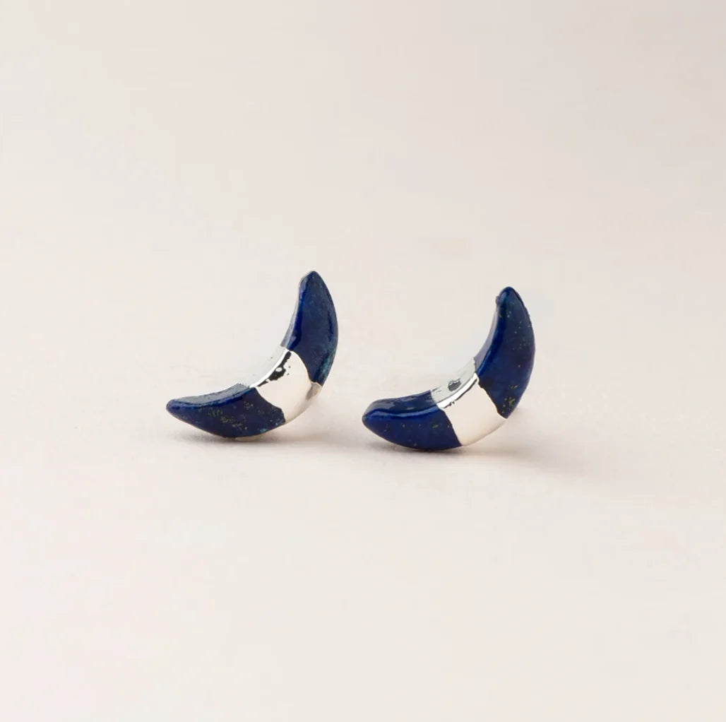 A pair of blue crescent moon stud earrings with a gold foil band on a semi-precious gemstone.