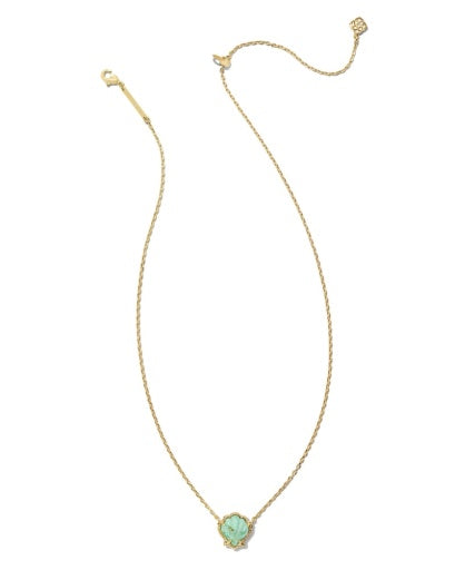 Gold necklace with a green heart-shaped pendant on a white background