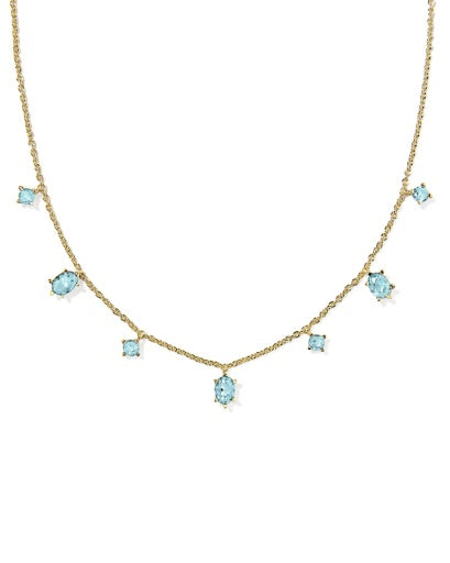 Gold necklace with blue gemstones on a white background