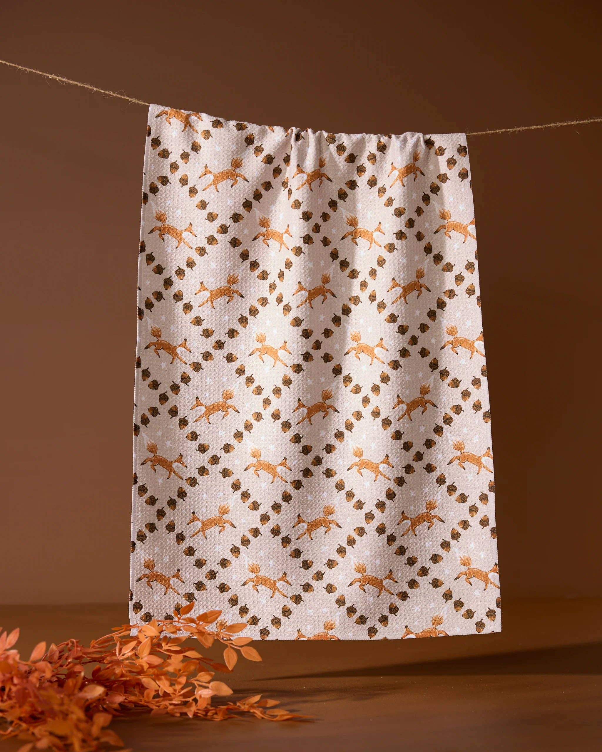 Towel with deer pattern hanging on a line against a brown background