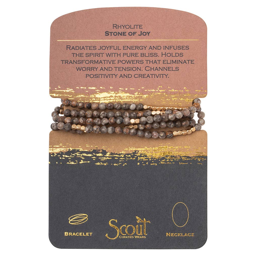 A Rhyolite stone bracelet wrapped around a card with the text 'RHYOLITE STONE OF JOY' and the brand 'SCOUT'.