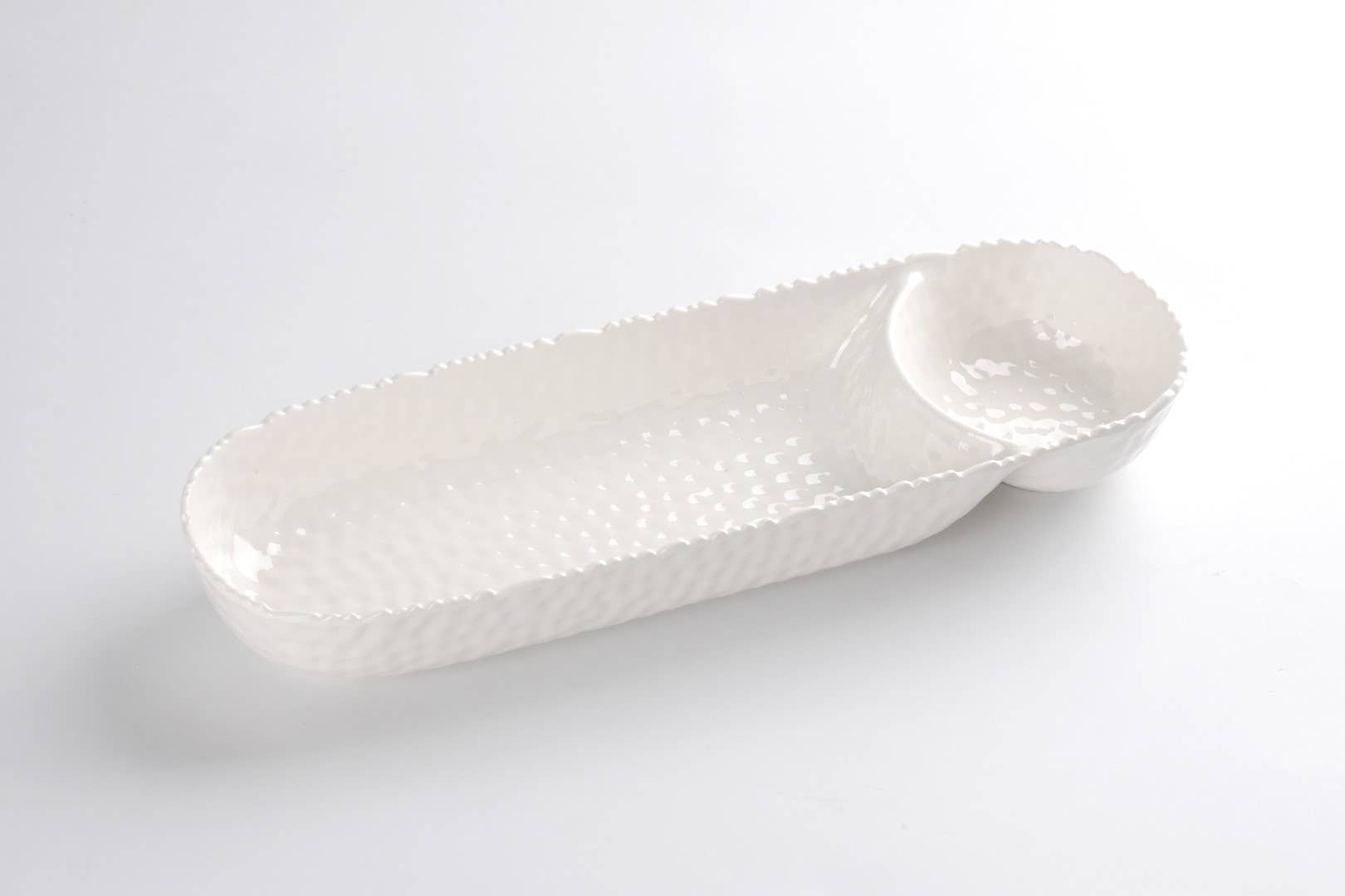 White ceramic serving dish with textured surface on a light gray background