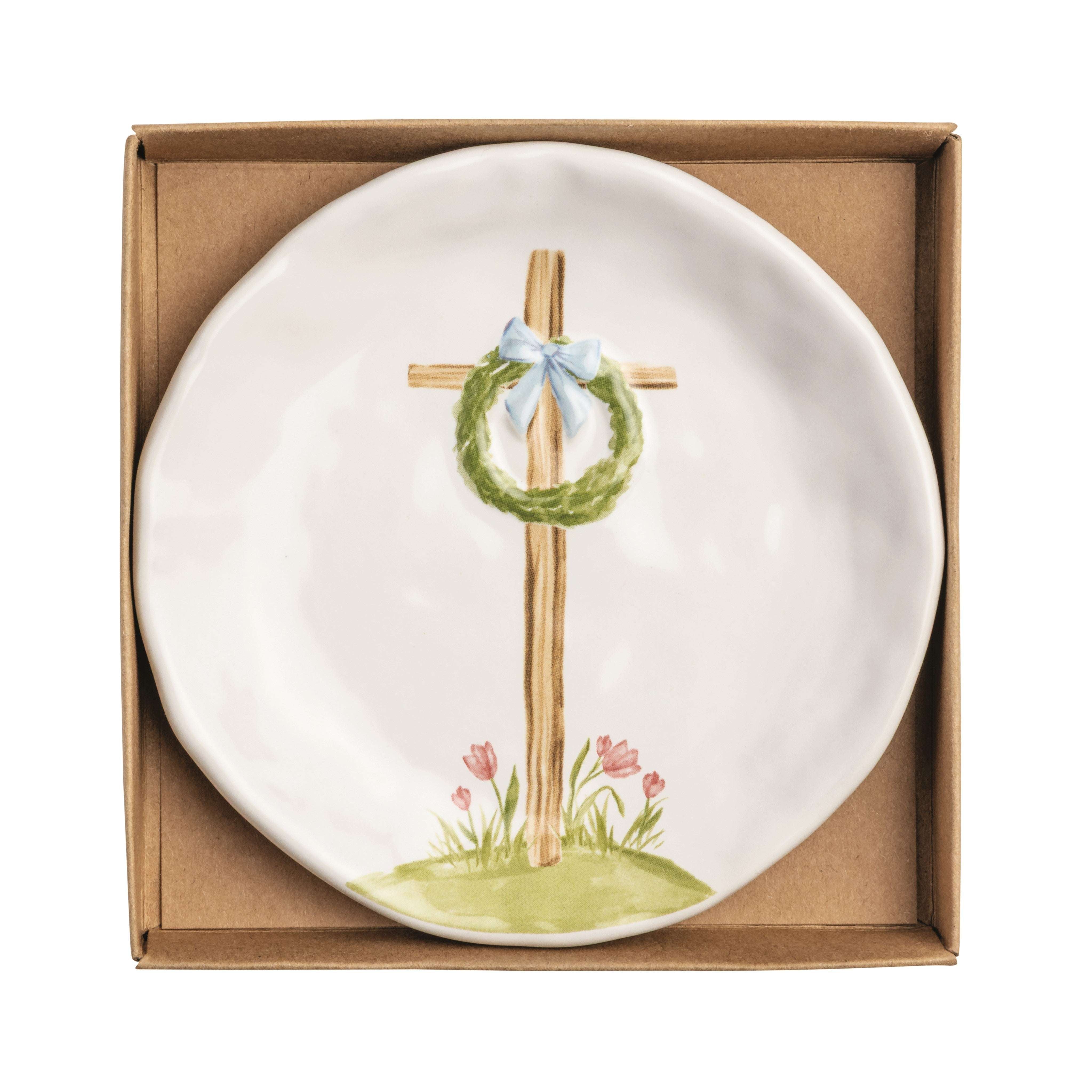 Decorative plate with a cross and wreath design in a cardboard box