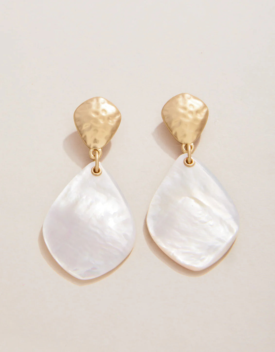 A pair of drop earrings with mother-of-pearl pendants and matte gold plating on posts.
