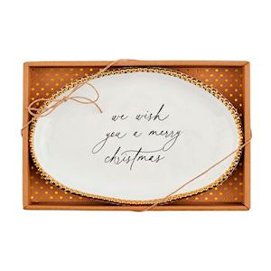 Decorative plate with 'we wish you a merry Christmas' text in a gold box.