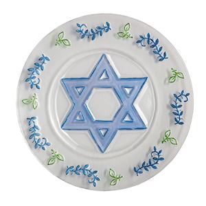 A white ceramic plate featuring a blue Star of David in the center, surrounded by a border of blue and green floral patterns.