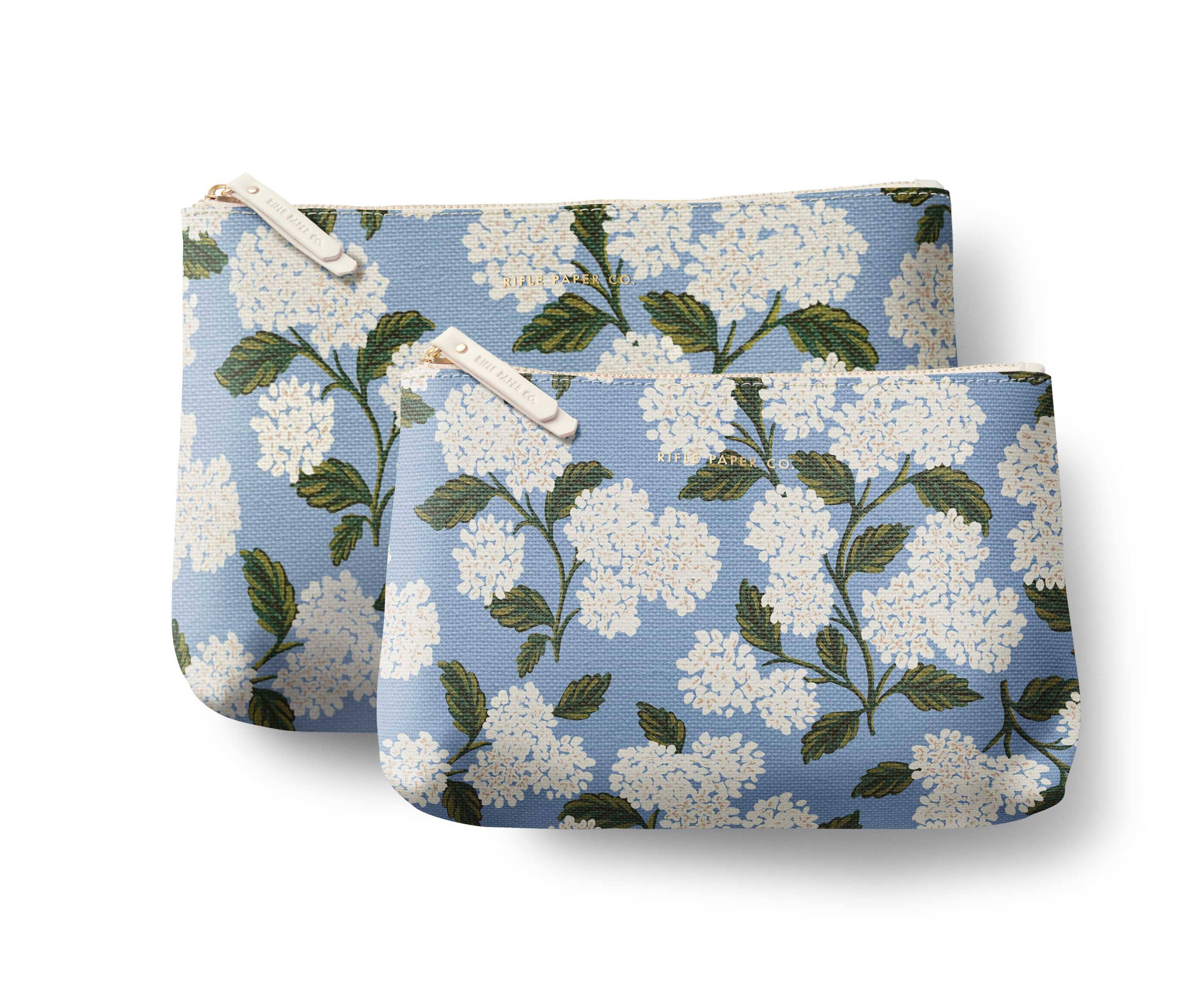 Two pouches with white floral pattern on a blue background