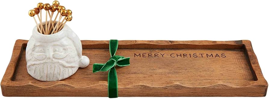 Wooden tray with 'Merry Christmas' engraving, white ceramic holder with gold skewers, and green velvet bow.