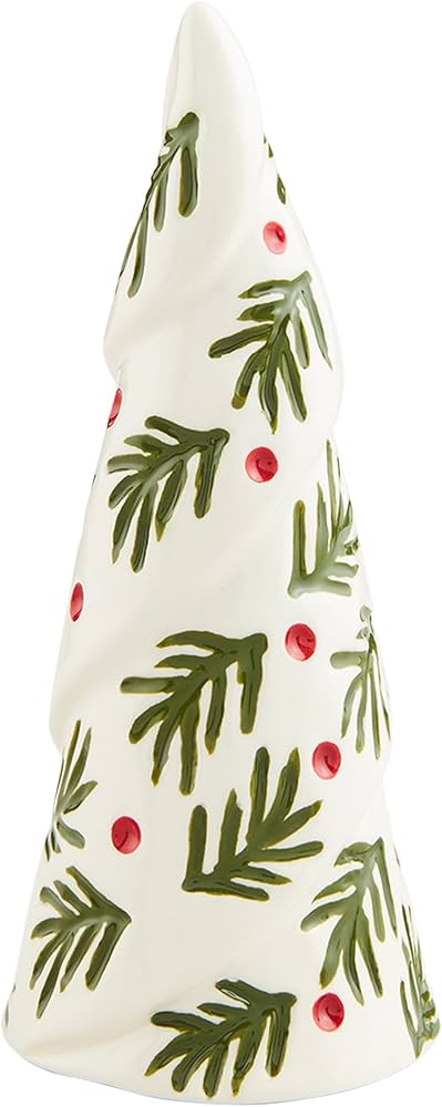 Decorative Christmas tree-shaped candle with green leaves and red berries on a white background