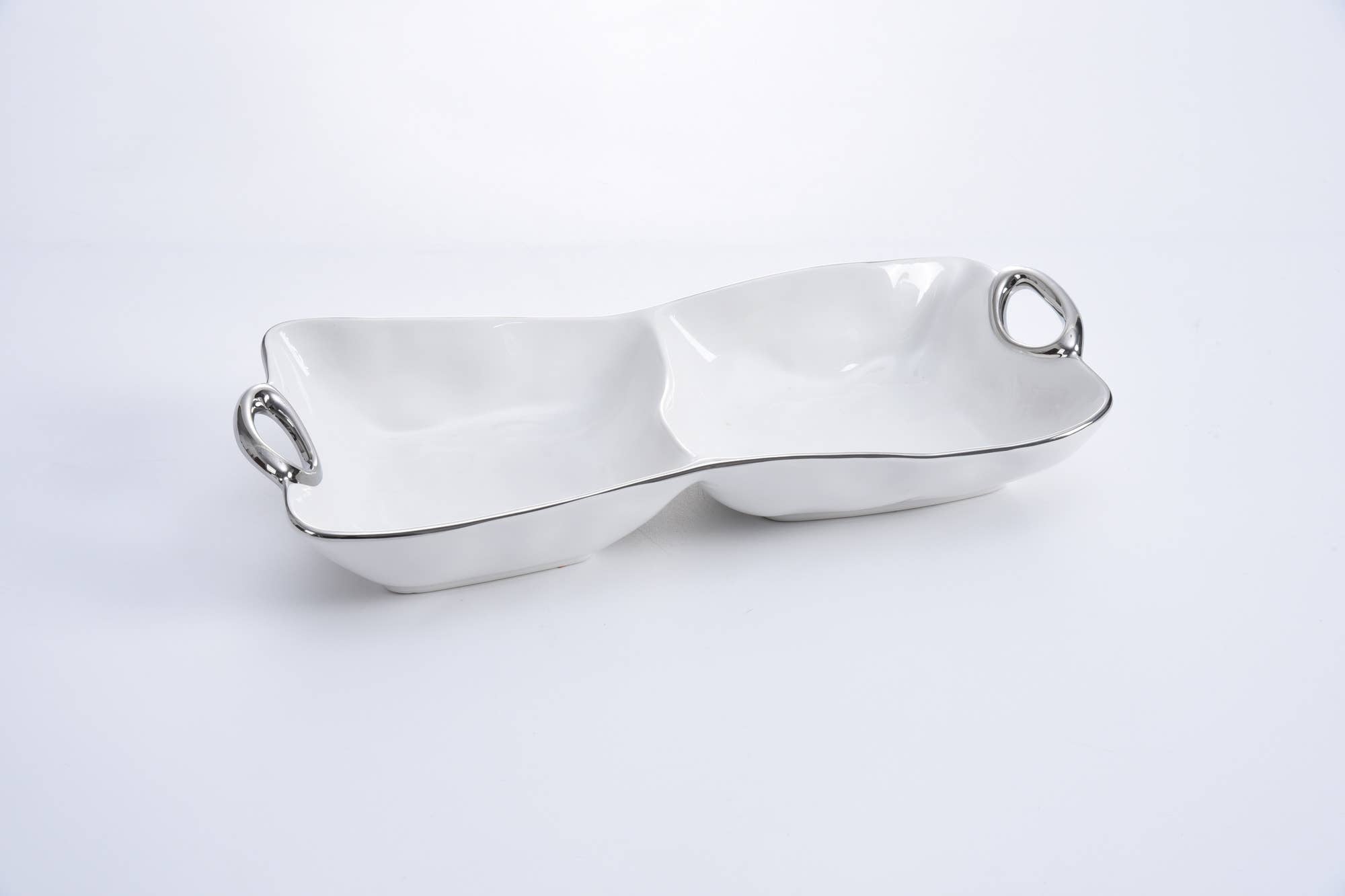 White ceramic fruit bowl with silver handles on a light gray background
