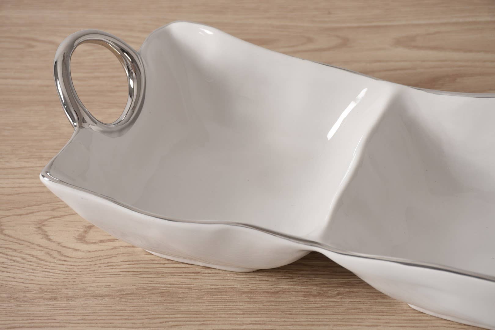 White ceramic serving dish with a handle on a wooden surface
