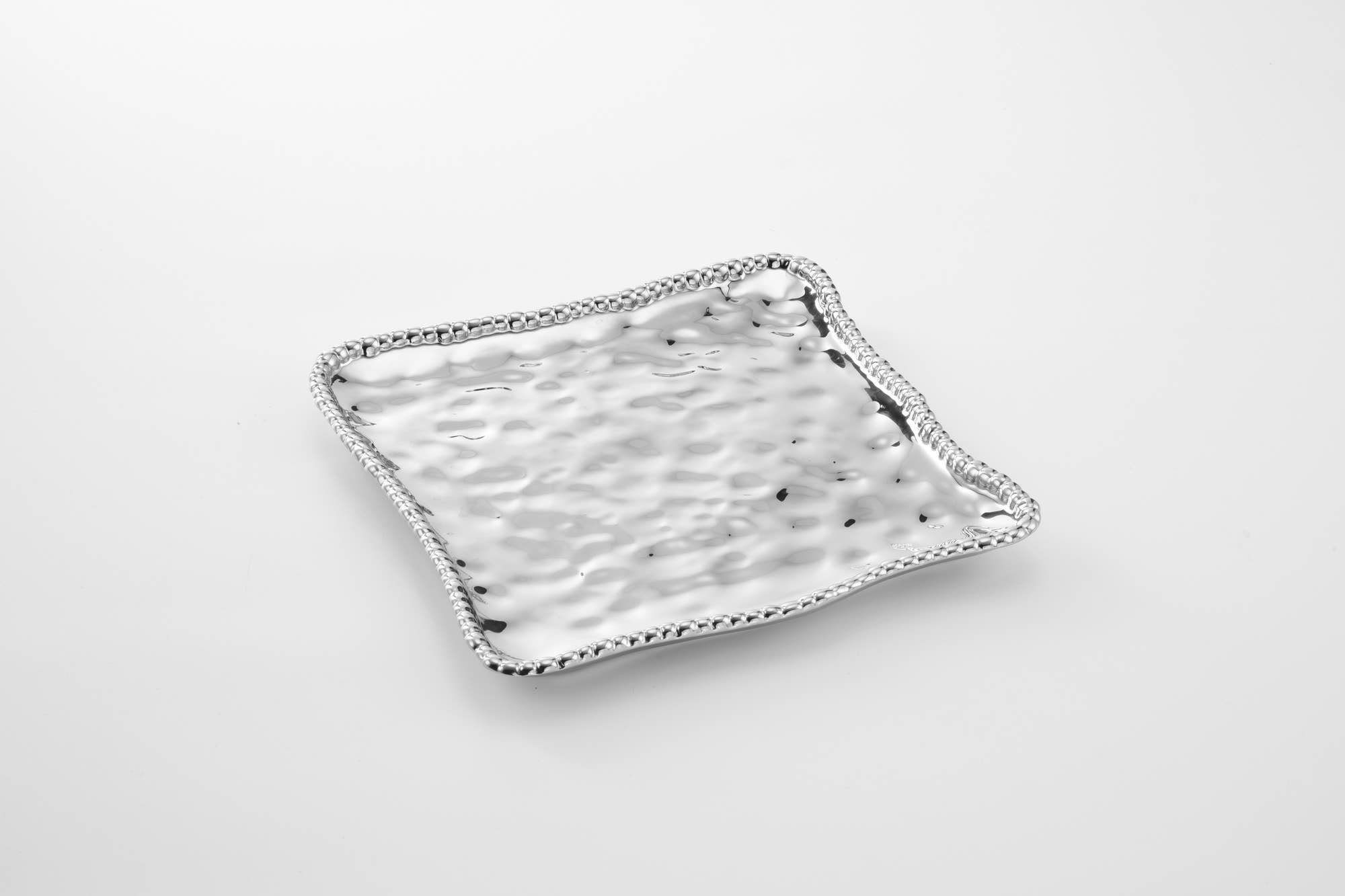 Square ceramic plate with textured edge on a light gray background
