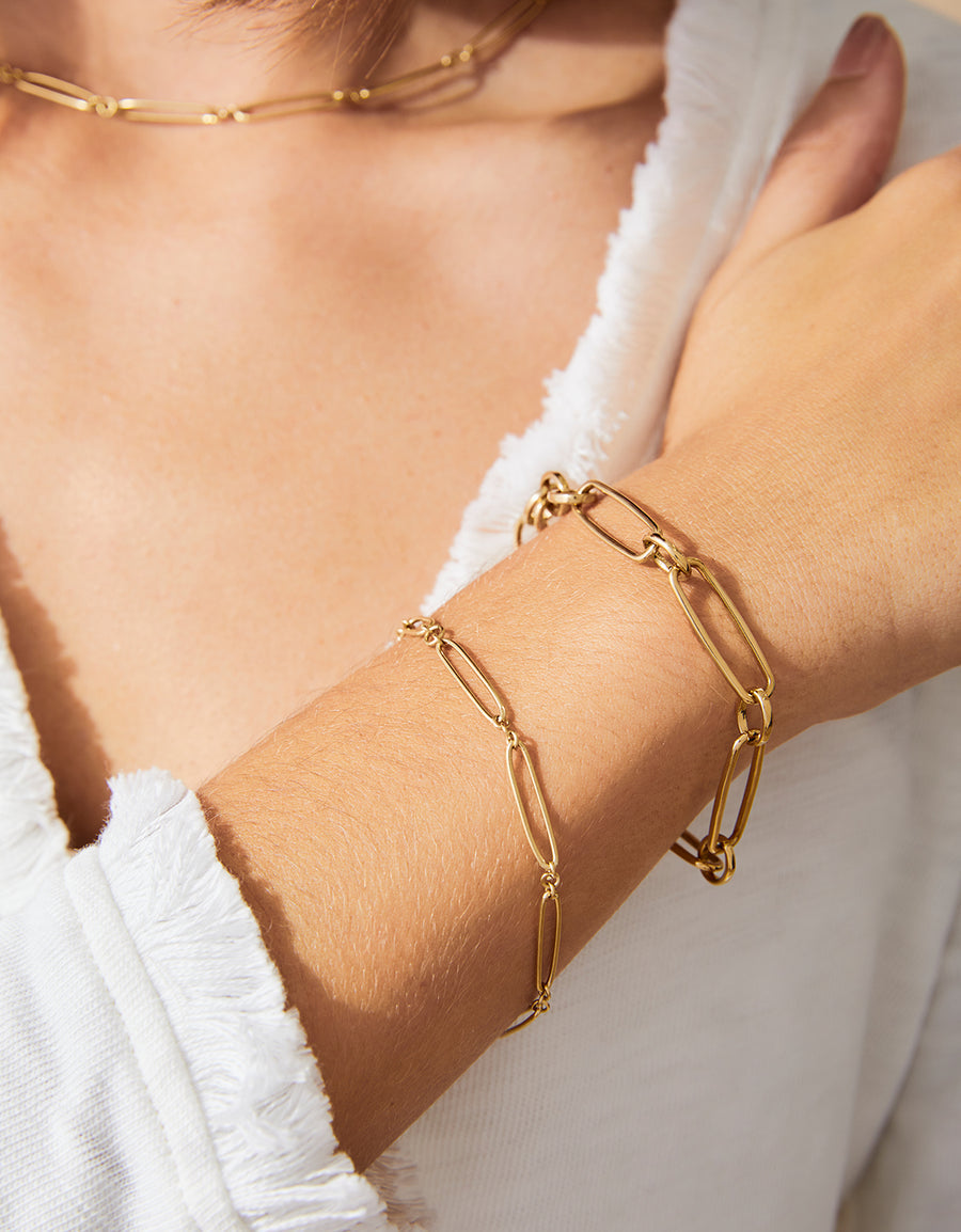 Gold chain bracelet on a person's wrist with a blurred background
