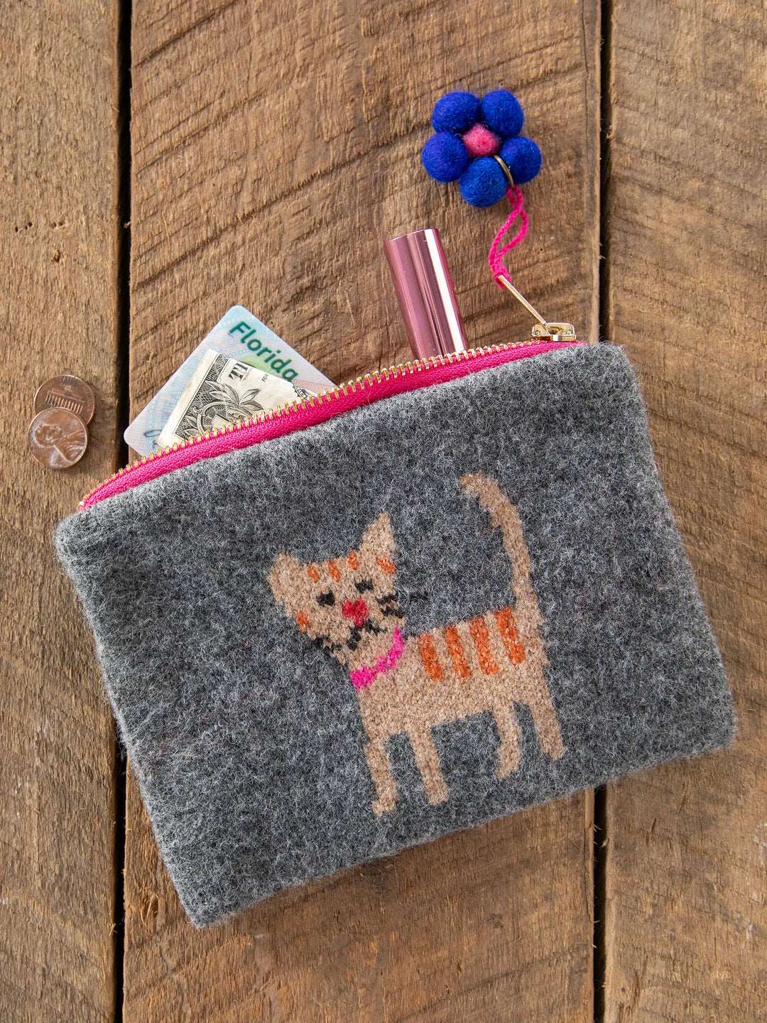 Gray pouch with a cat design on a wooden surface