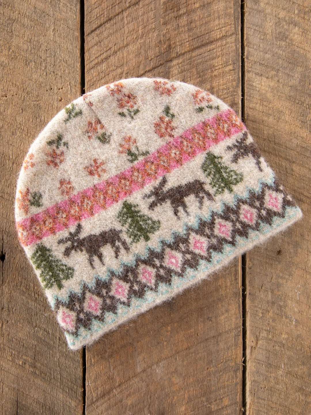 Knitted hat with horse pattern on a wooden surface