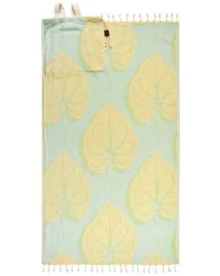 A green towel bag with a pattern of white monstera leaves, featuring twisted tassels and a zipper pocket at the top.