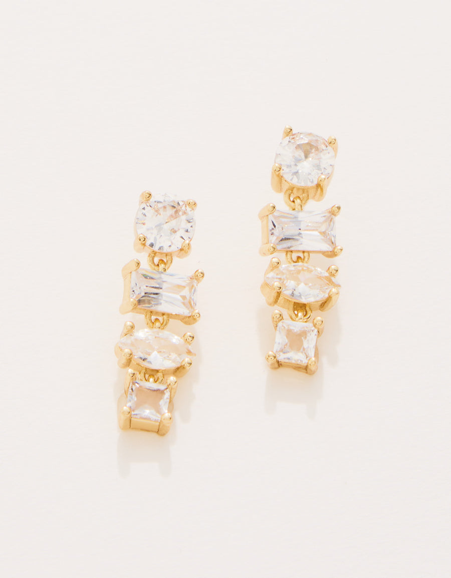 Gold earrings with clear gemstones on a white background