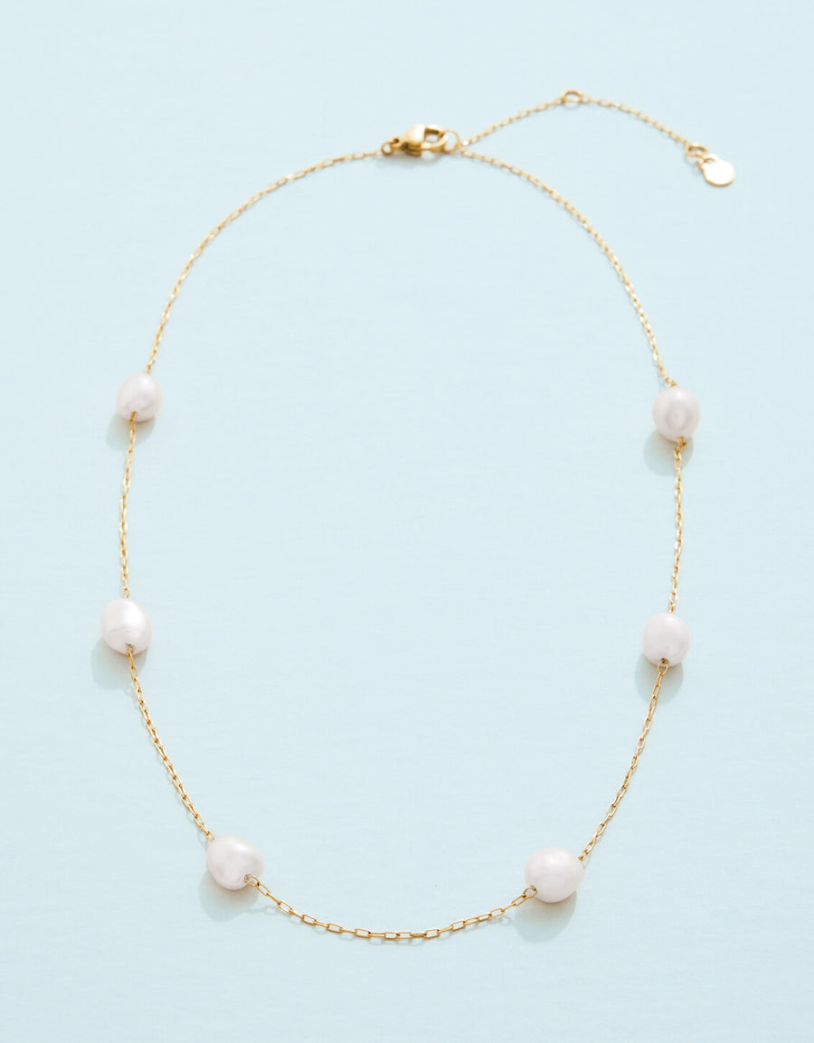 Pearl necklace on a light blue background