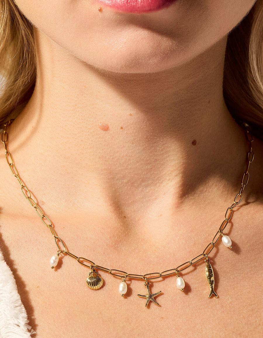 Necklace with various charms worn by a person