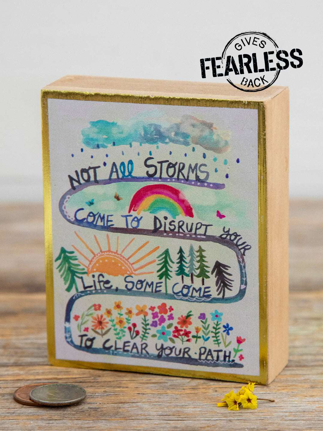 Decorative box with motivational quote and illustrations on a wooden surface