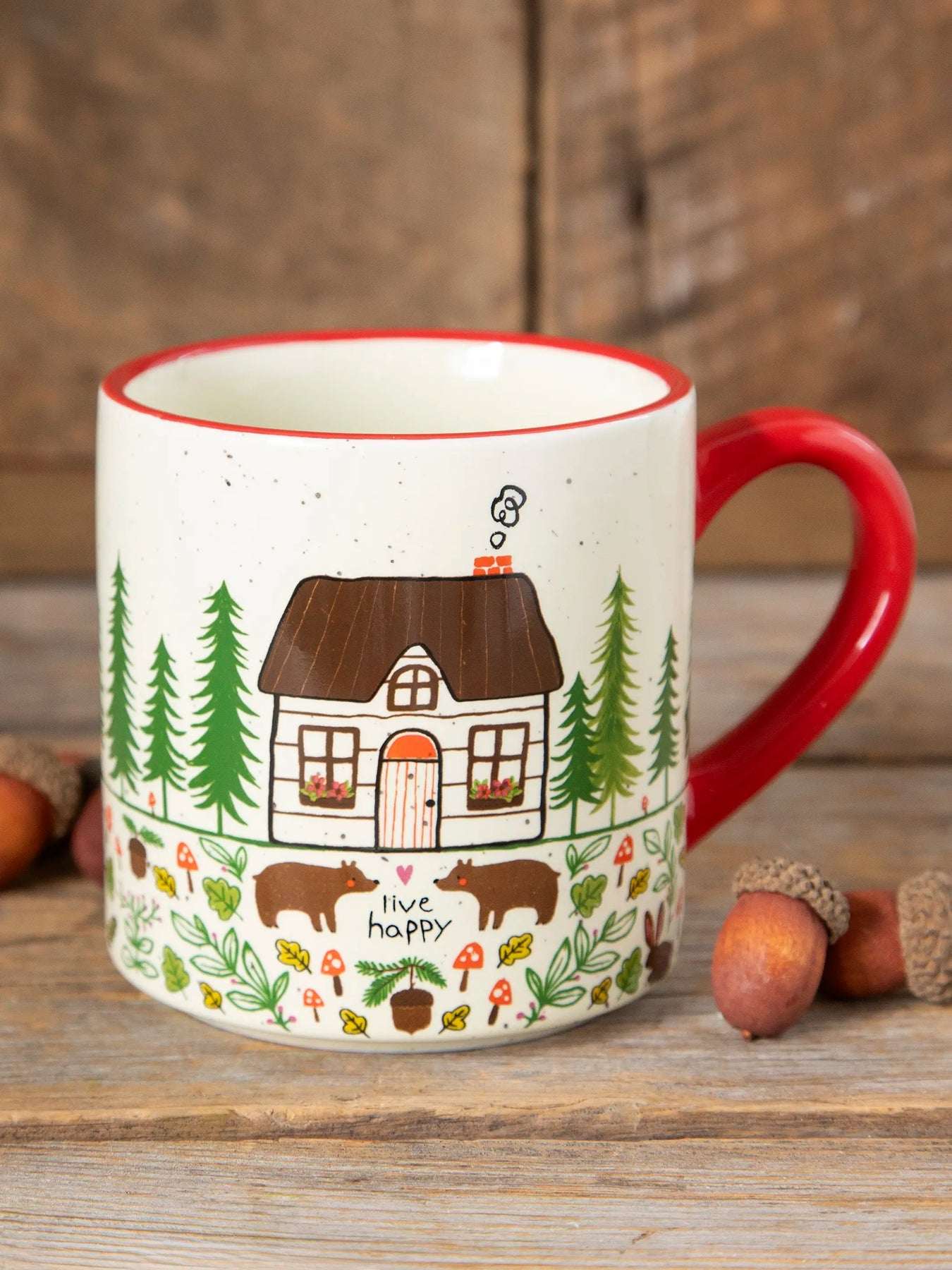 Mug with a house and nature design on a wooden surface